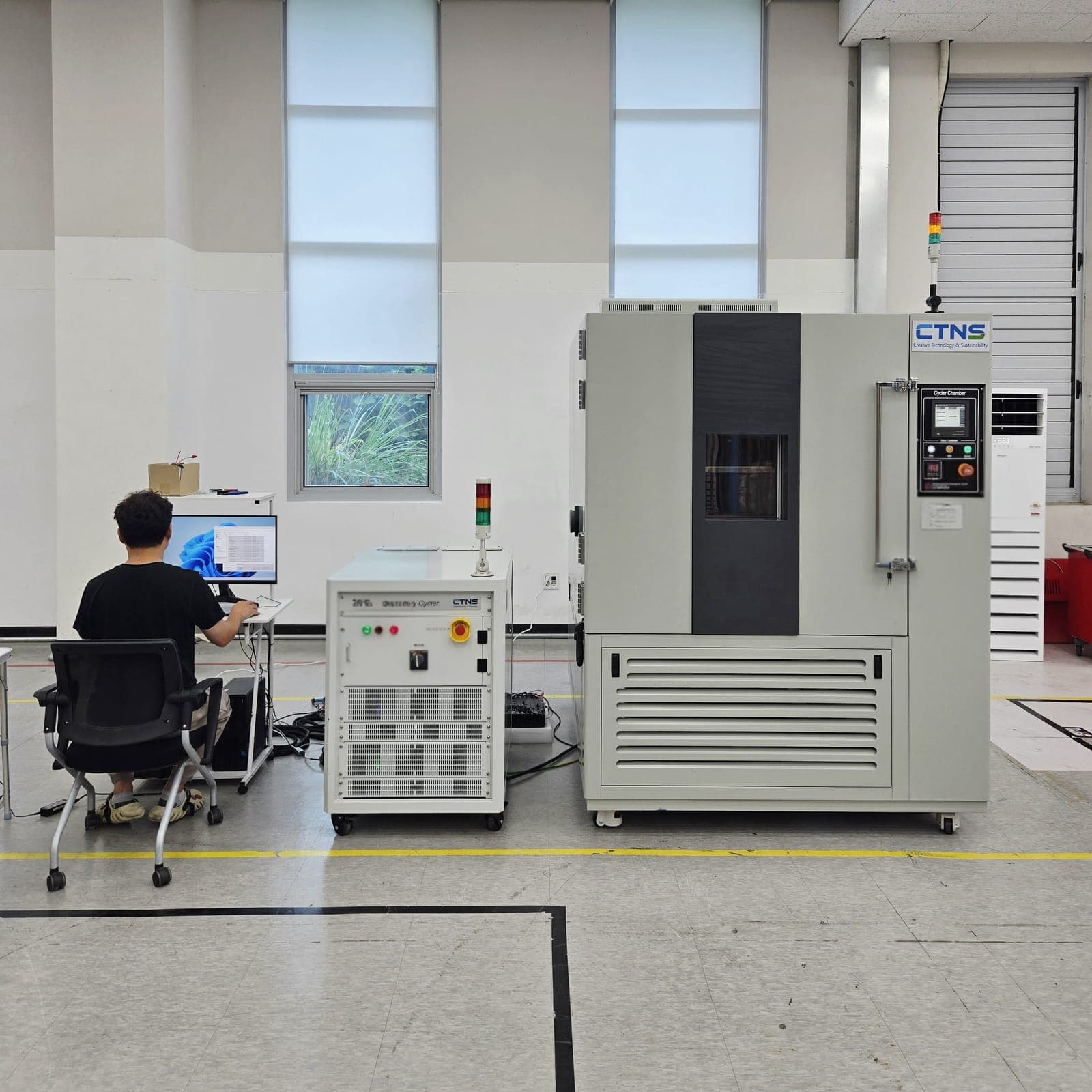 CTNS 시험실의 배터리 사이클러와 항온 챔버, 옆에서 연구원이 시험 화면을 보고 있다